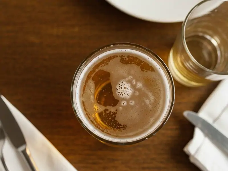 A pint glass of pale lager