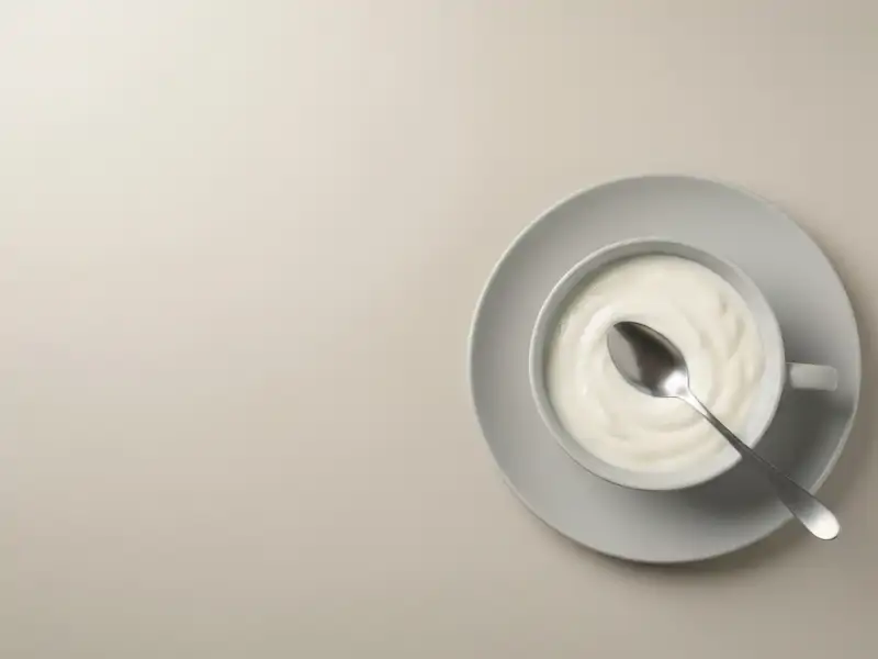 A bowl of plain Greek yogurt with a spoon