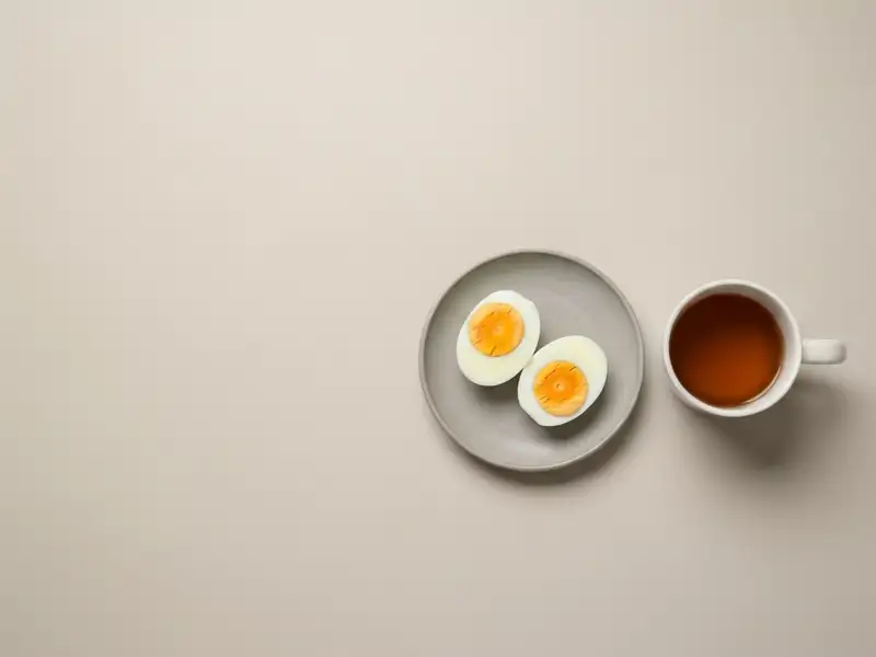 Two hard-boiled eggs peeled on a small plate