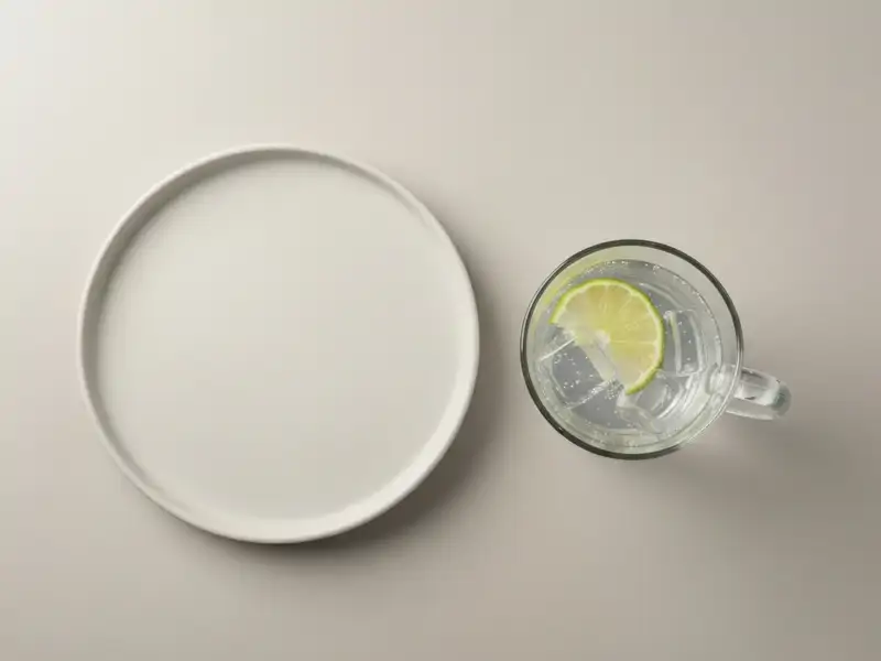 A clear glass of vodka soda with a lime wedge